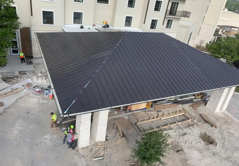 Metal roofing installation team working on a commercial building in Palmer